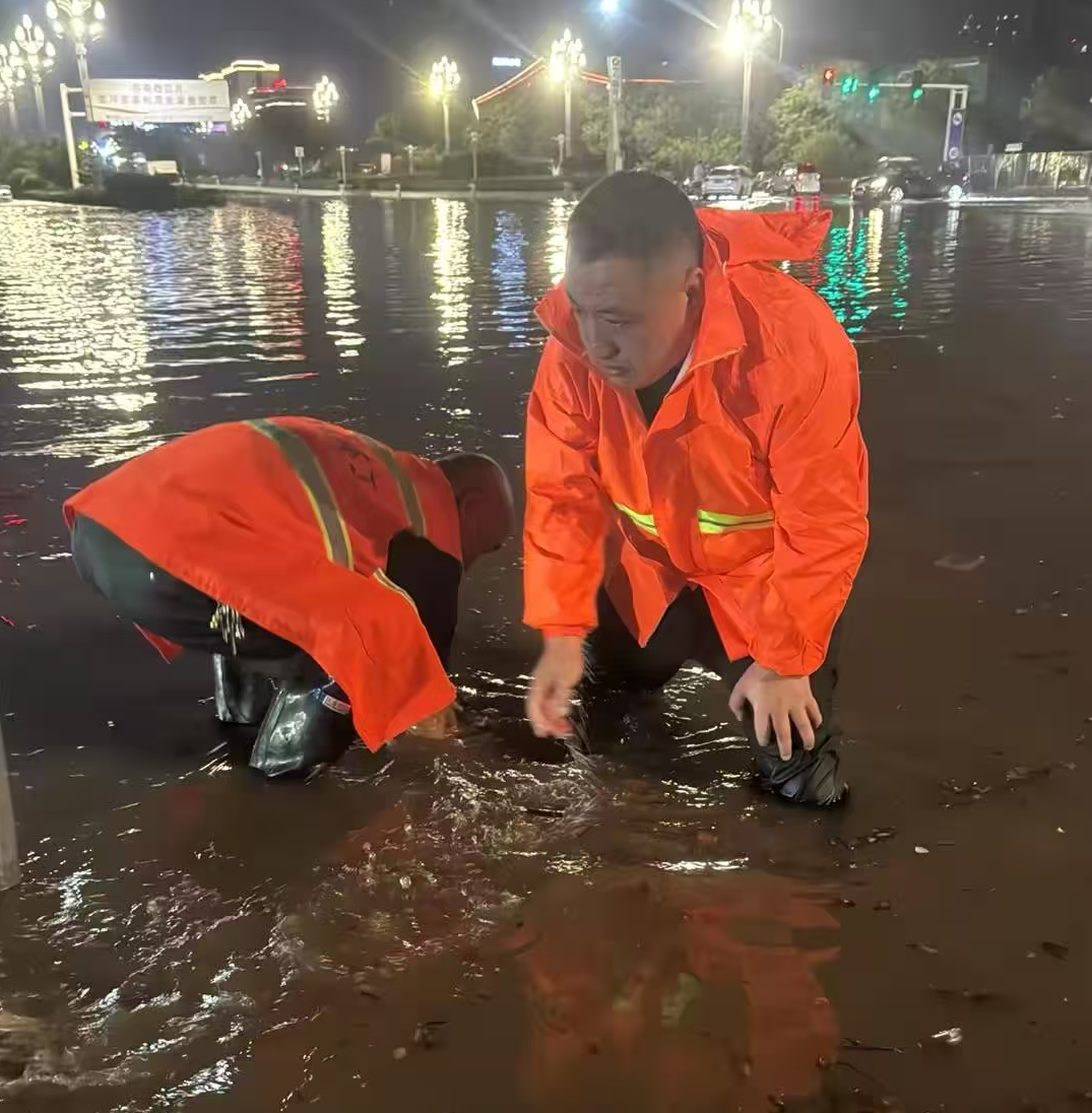 1758494132158.png 神州環(huán)境副總經(jīng)理孔凡超帶領(lǐng)環(huán)衛(wèi)團(tuán)隊在雨中疏通下水道口.png